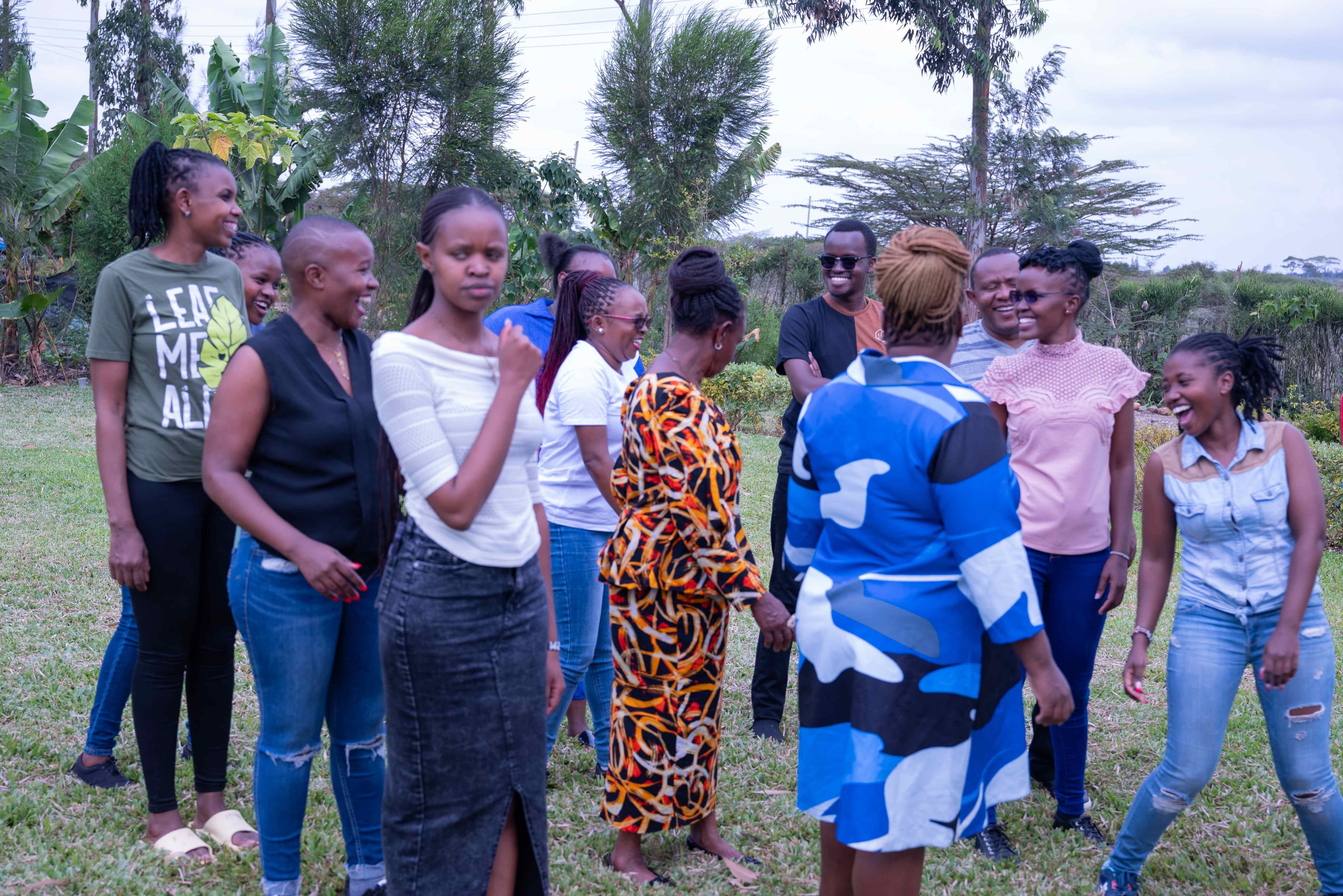 Group of people engaged in team-building activities on the farm lawn, showing diverse participants enjoying outdoor group exercises in a natural setting